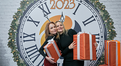 Сотрудники компании ВЕКПРОМ с подарками на фоне часов